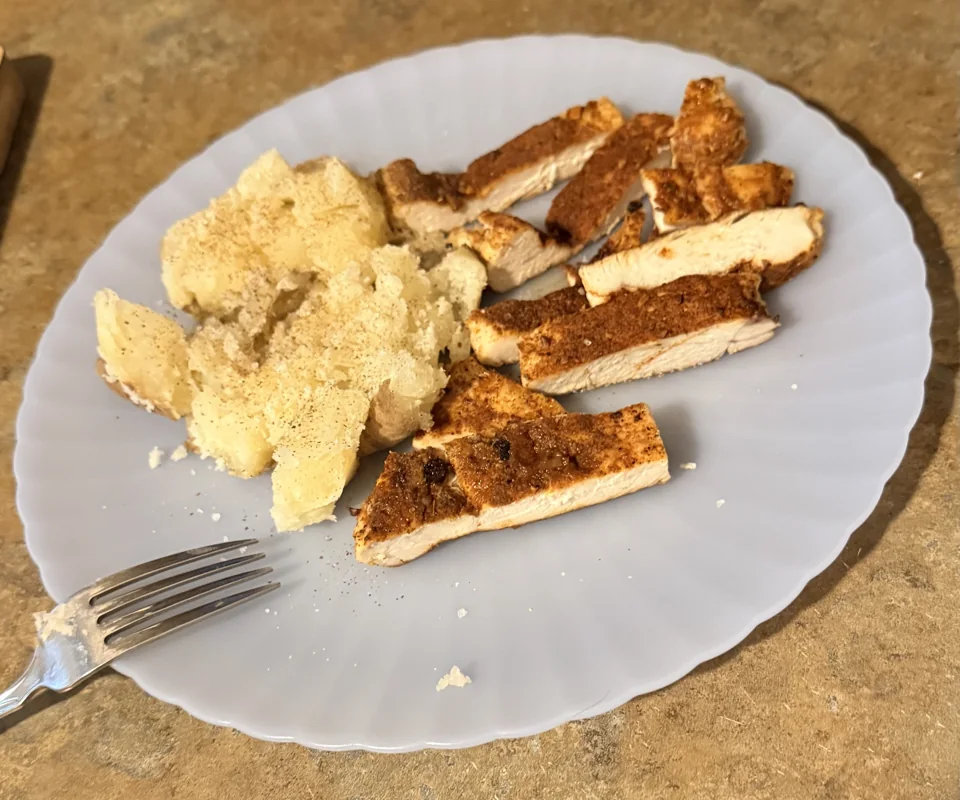 A home-cooked plate of seasoned sliced chicken and potatoes from James's kitchen.